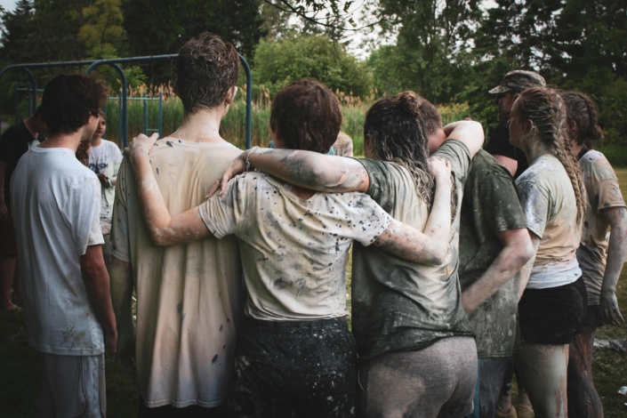 teens huddled together with their arms hugging around each other