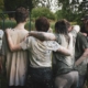 teens huddled together with their arms hugging around each other